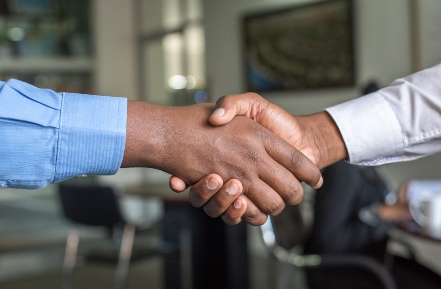 two person in long sleeved shirt shakehand